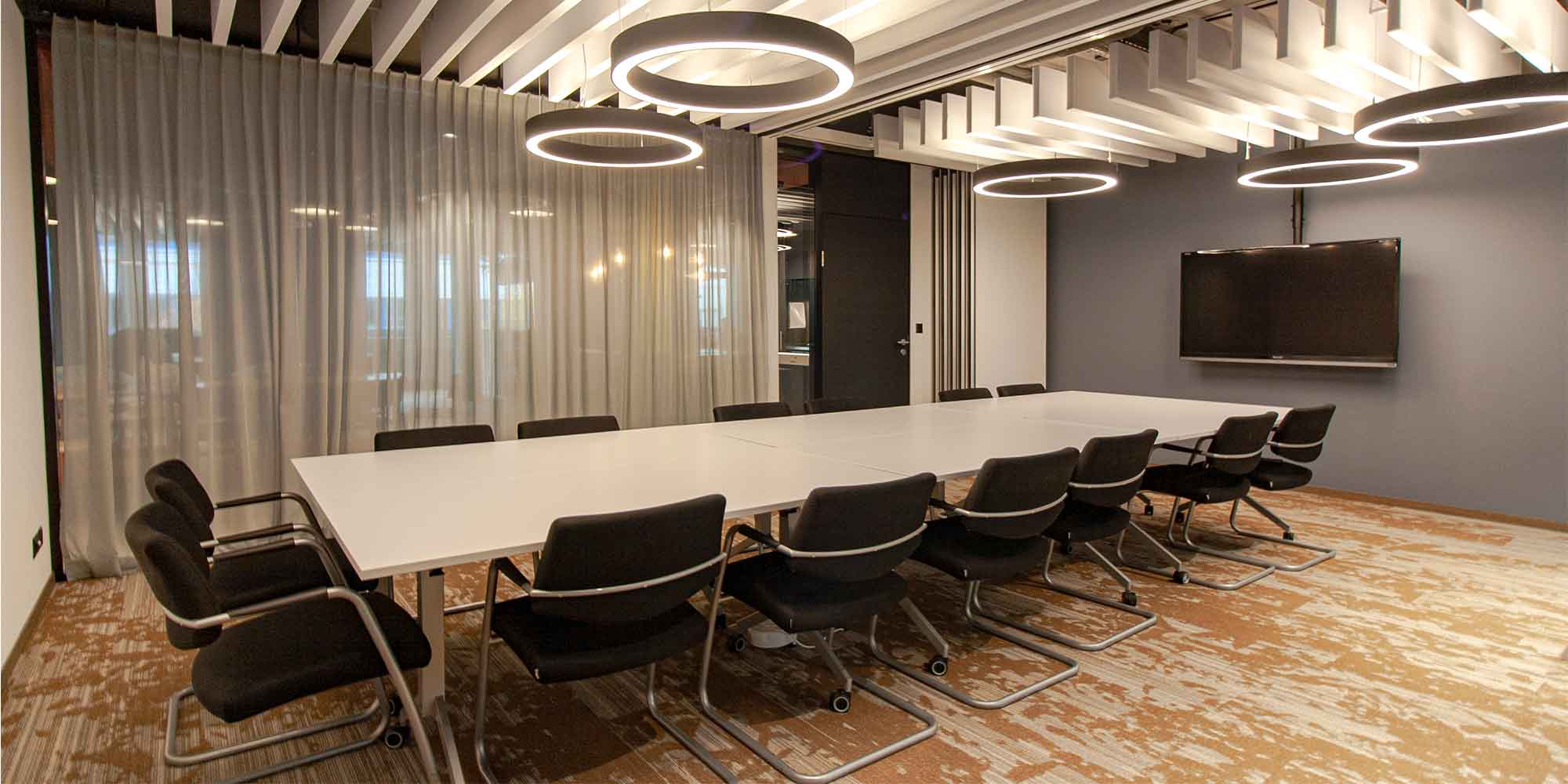 Dieses Sitzungszimmer ist mit mehreren Ringostar Pendeleluchten von lightnet ausgestattet. Diese geben eine optimale Grundbeleuchtung und die Leuchte wirkt als element der Raumgestaltung